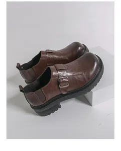 Nahaufnahme von braunen Vintage-Monkstrap-Loafern mit dicker Sohle und Metallschnalle.