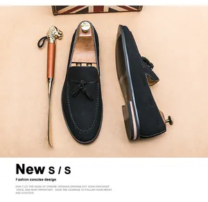 Detailed view of black suede loafers for men featuring elegant tassels and pointed toe design