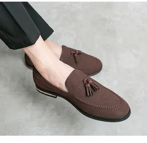 Macro detail of stylish brown suede loafers featuring vintage decorative tassel accents