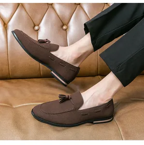 Detailed macro view showing the texture and design of men's brown suede tassel loafers