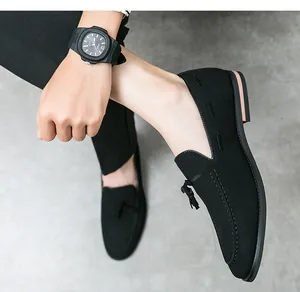 Detailed view of men's black suede loafers featuring stylish tassels and pointed toes