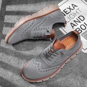 Detailed view of grey fly-knit casual shoes with brogue pattern and soft rubber sole.