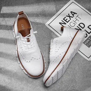 Top-down detailed view of white fly-knit casual shoes with brown leather accents