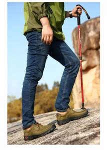 Professional side view of men's olive green leather outdoor hiking shoes on rocky terrain