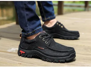Detailed close-up of men's black top-grain leather outdoor shoes on a boardwalk.