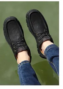 Top-down view of men's black genuine leather casual outdoor shoes worn with jeans