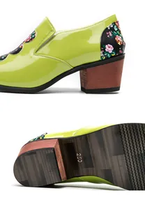 Detail of green patent leather shoes showing floral patterns and wood grain heel