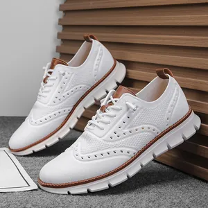 Detail of white breathable knitted casual shoes with brown leather accents and thick sole.