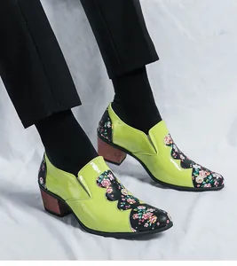 Detailed macro view of lime green patent leather men's high heel shoes with floral patchwork