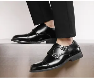 Detailed view of elegant men's black leather double monk strap shoes with brogue patterns