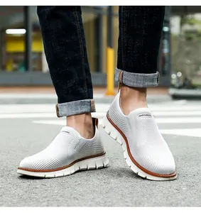 Detail der atmungsaktiven weißen Strick-Laufschuhe für Herren in einer Stadtumgebung.