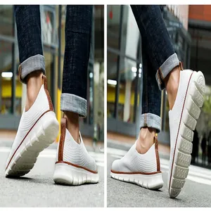 Detailansicht weißer, atmungsaktiver Strick-Slip-on-Sneaker für Herren in städtischer Umgebung.