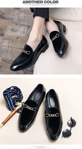 Detailed macro view of men's black patent leather loafers with decorative gold chain
