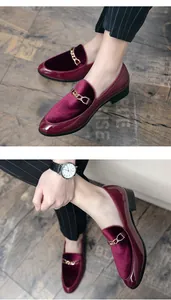 Close-up of burgundy velvet and patent leather loafers with a luxury gold chain detail