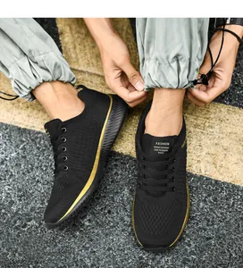 Vue détaillée de chaussures de course pour hommes en maille noire avec bordure dorée