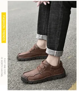 Side detail view of brown men's microfiber casual shoes with manual stitching on asphalt
