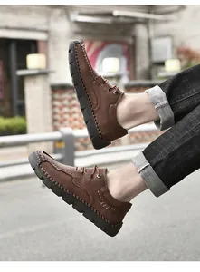 Detailed side view of brown microfiber men's casual shoes with artisan hand-stitched finish