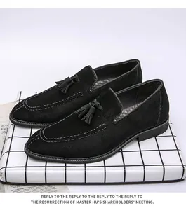 Primer plano detallado de mocasines de gamuza negra con borlas y costuras blancas elegantes