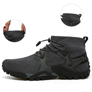 Dettaglio del colletto elastico e del tessuto mesh di una scarpa da trekking grigia.