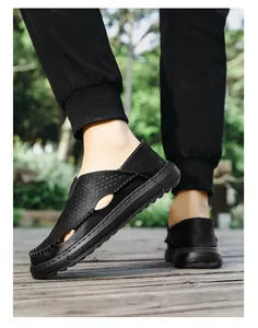 Nahaufnahme von atmungsaktiven schwarzen Leder-Sandalen für Herren auf einem Holzdeck.