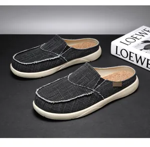 Detailed view of stylish black canvas men's slip-on mules with cork texture footbed