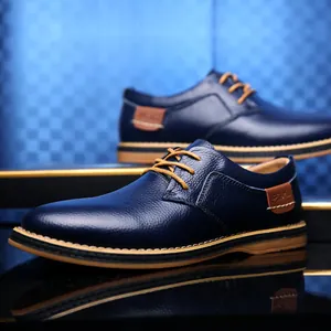Men's navy blue leather business dress shoes with tan laces and soft textured surface