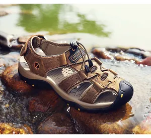 Close-up van bruine leren trekkingsandalen op natte rivierstenen in de buitenlucht