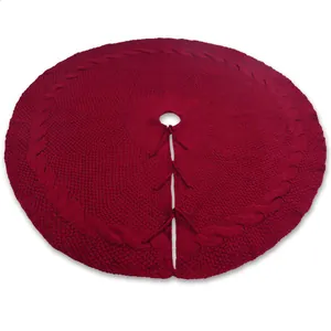 Detailweergave van een ronde rode gebreide kerstboomrok met klassieke kabelpatronen