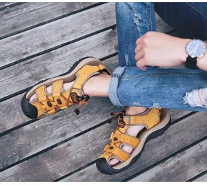 Heren outdoor sandalen van bruin microfiber leer met gesloten neus op een houten dek.