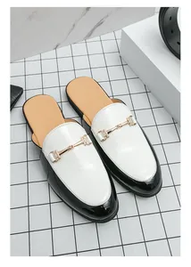 Detailed shot of modern black and white patent leather men's loafers with golden bit