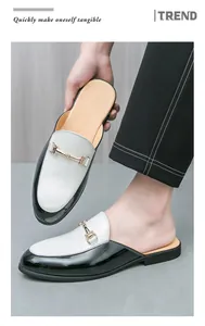Detailed shot of stylish men's black and white half-loafers with gold horsebit