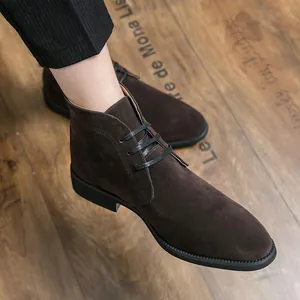 Λεπτομερής όψη από ανδρικές vintage καφέ σουέτ Chukka μπότες σε ξύλινο δάπεδο