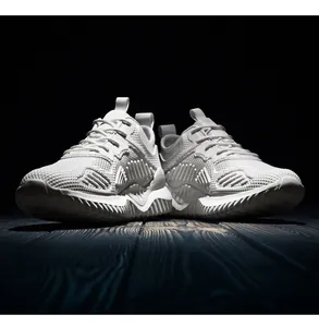 Close-up van witte ademende flyknit sneakers op een getextureerde donkere vloer