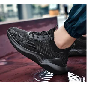 Gedetailleerde close-up van ademende zwarte fly-woven sneaker die in een plas water stapt