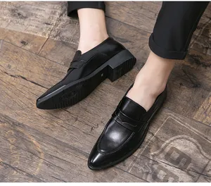 Detailansicht schwarzer Herren-Business-Lederschuhe mit spitzer Kappe auf Holz