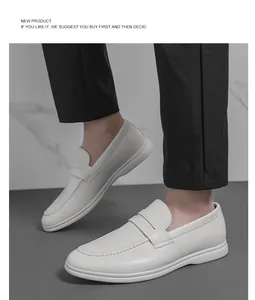 Vue détaillée de mocassins classiques en cuir blanc pour hommes avec un pantalon noir