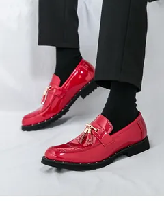 Close-up of vibrant red patent leather loafers with gold tassel and metal buckle