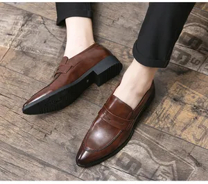 Nahaufnahme von eleganten braunen Leder-Loafers mit spitzer Kappe auf einem Holzboden
