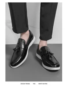 Vue détaillée de mocassins en cuir noir à glands portés avec un pantalon habillé