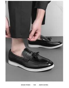 Vue détaillée de mocassins en cuir noir avec glands et semelles blanches