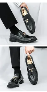 Close-up of men's black patent leather loafers with gold tassel and metal bit hardware