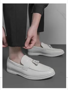 Mocassins blancs à glands pour hommes avec pantalon noir pour un look décontracté.