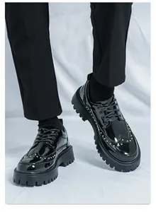 Nahaufnahme von schwarzen Herren Brogue Schuhen aus Lackleder mit dicker Profilsohle