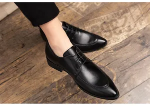 Nahaufnahme eleganter schwarzer Lederschuhe mit spitzer Kappe und Schnürung im Detail