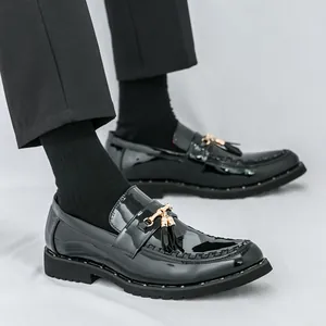 Elegant shiny black men's business loafers featuring gold tassels and a chunky sole