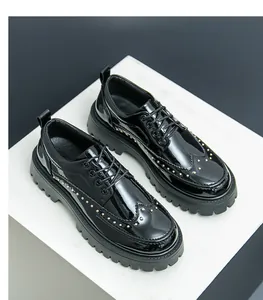 Detailansicht von schwarzen Brogue-Schuhen aus Lackleder mit dicken Profilsohlen und Goldnieten