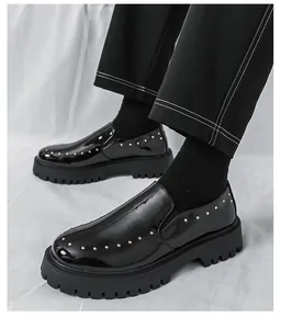 Nahaufnahme von schwarzen Lackleder-Plateau-Loafers mit stilvollen goldenen Nieten.