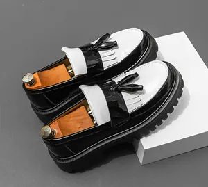 Nahaufnahme von schwarz-weißen Leder-Quasten-Loafers mit dicken, klobigen Sohlen