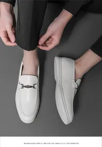 Détail de mocassins en cuir blanc pour hommes avec une boucle métallique élégante
