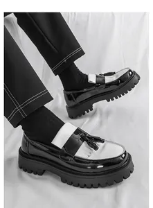 Makro-Detailaufnahme von schwarz-weißen Plateau-Kiltie-Loafers mit stilvollen Quasten